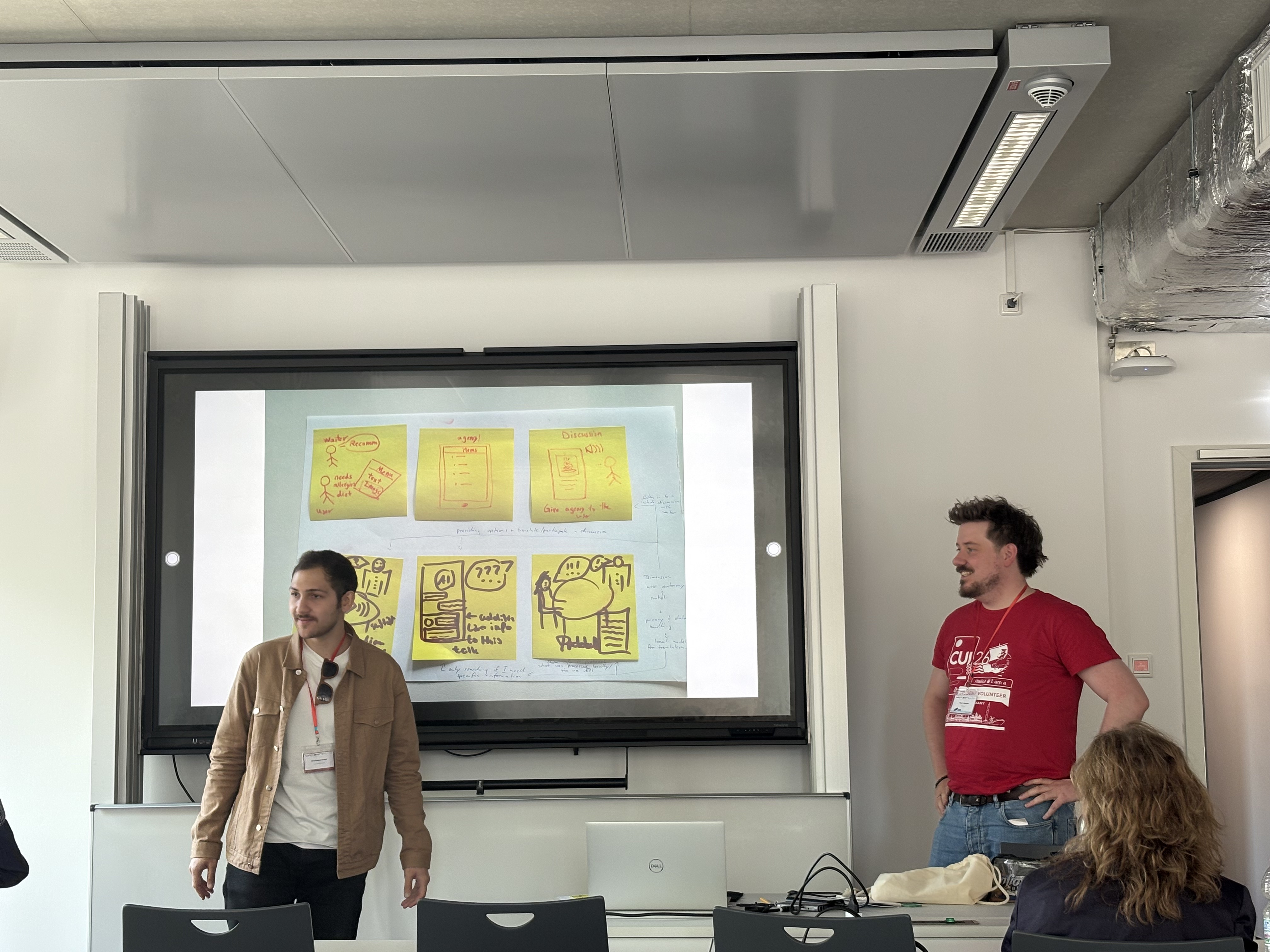 Two members of group 3 stand on the sides of the display presenting their storyboard.