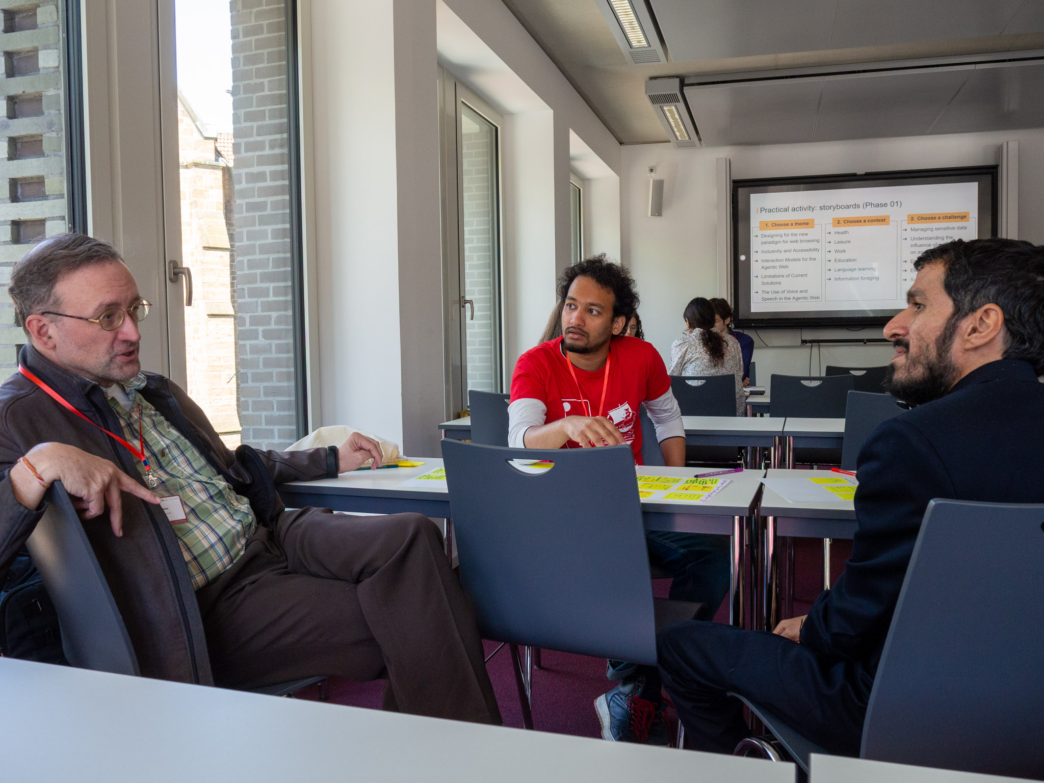 A participant talking while with his two groupmates listening.